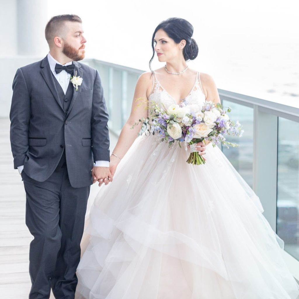 bride and groom hold hands on the terrace of the conrad ft. lauderdale ballroom