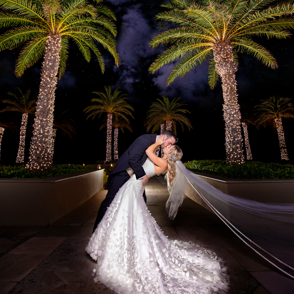 bride and groom kiss under palm trees at harbor beach marriott ft. lauderdale
