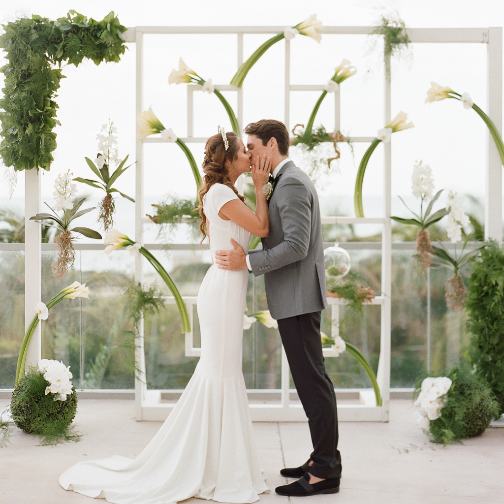 bride and groom kiss in front of a cala lily structure at 1 hotel south beach