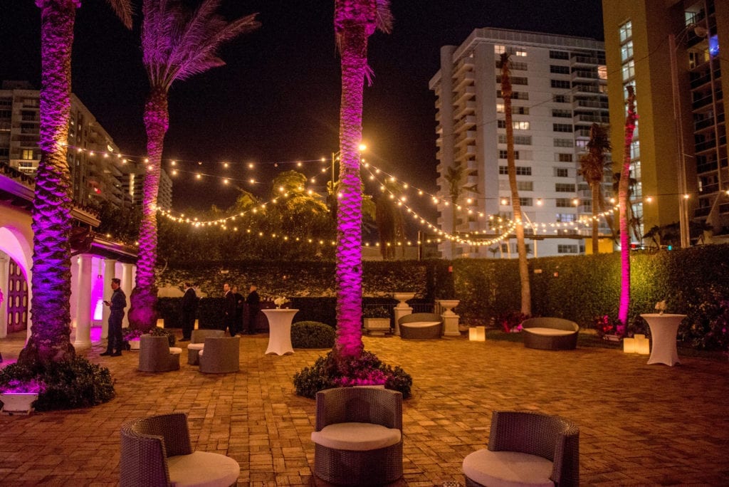 The Bath Club courtyard was lit with bistro lights and colored uplights to give an evening Miami Beach glow