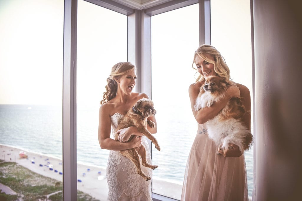 The bride wanted her dogs to be included in her wedding day, so they posed for photos while she wore her Eve of Milady wedding dress in her Eden Roc bridal suite.