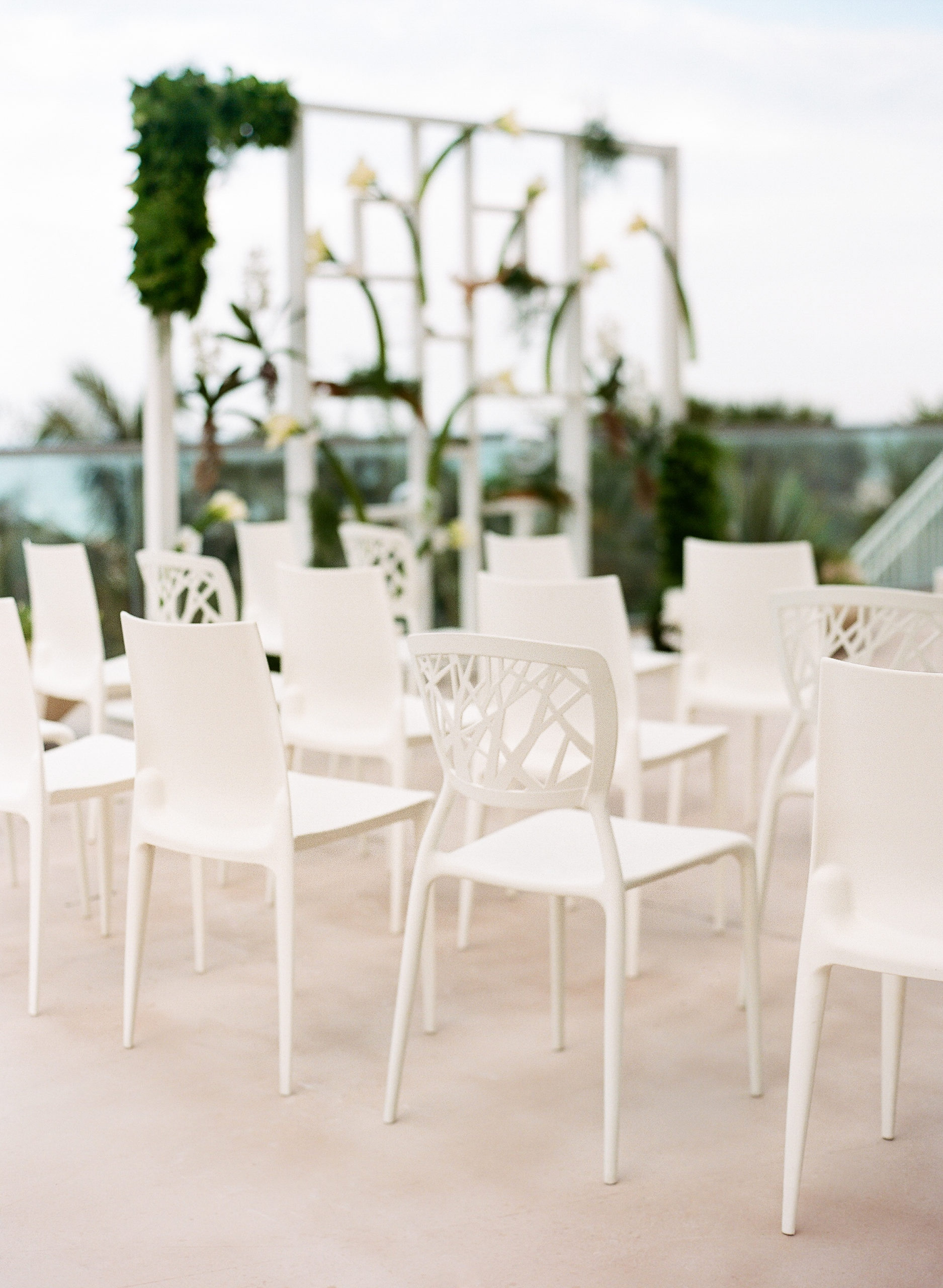 A Unique ceremony setup placed guest chairs around the couple to form an open circle encasing the couple and showcasing the custom ceremony structure with calla lilies, orchids, and greenery at the 1 Hotel South Beach