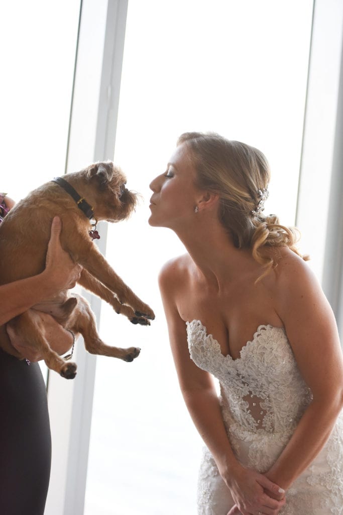 The bride takes a photo with her dog on her wedding day, wearing a gorgeous Eve of Milady wedding gown