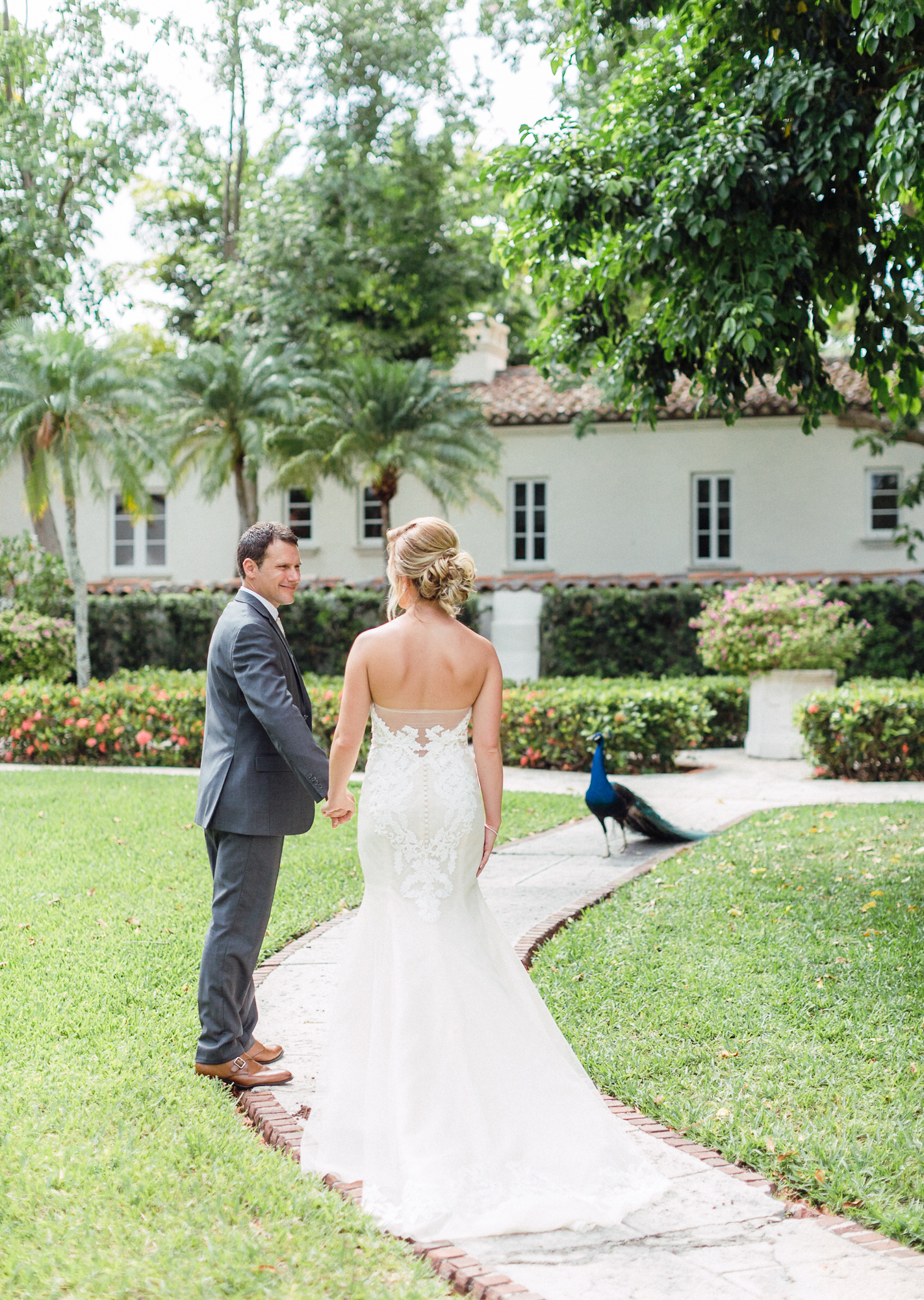 The bride and groom take their wedding photos on fisher island and are greeted by a peacock