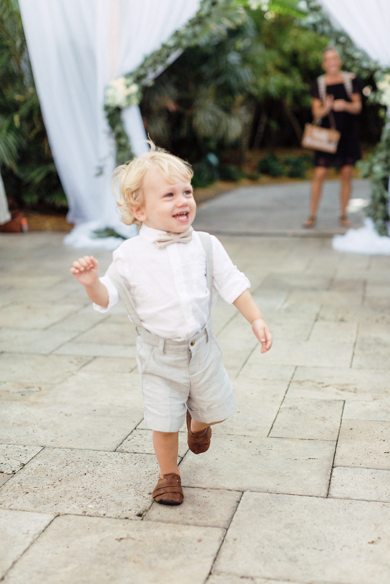 The ring bearer excitedly runs down the aisle once he sees his dad!