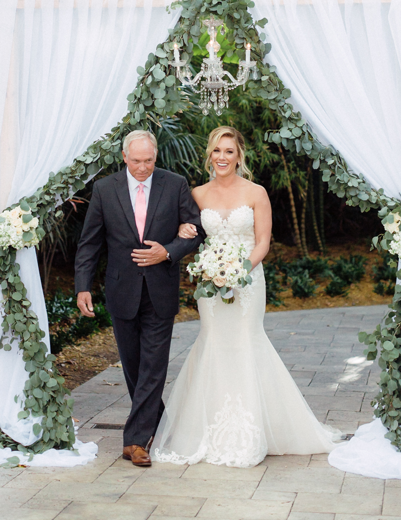 The bride walked out from a draped and chandelier archway
