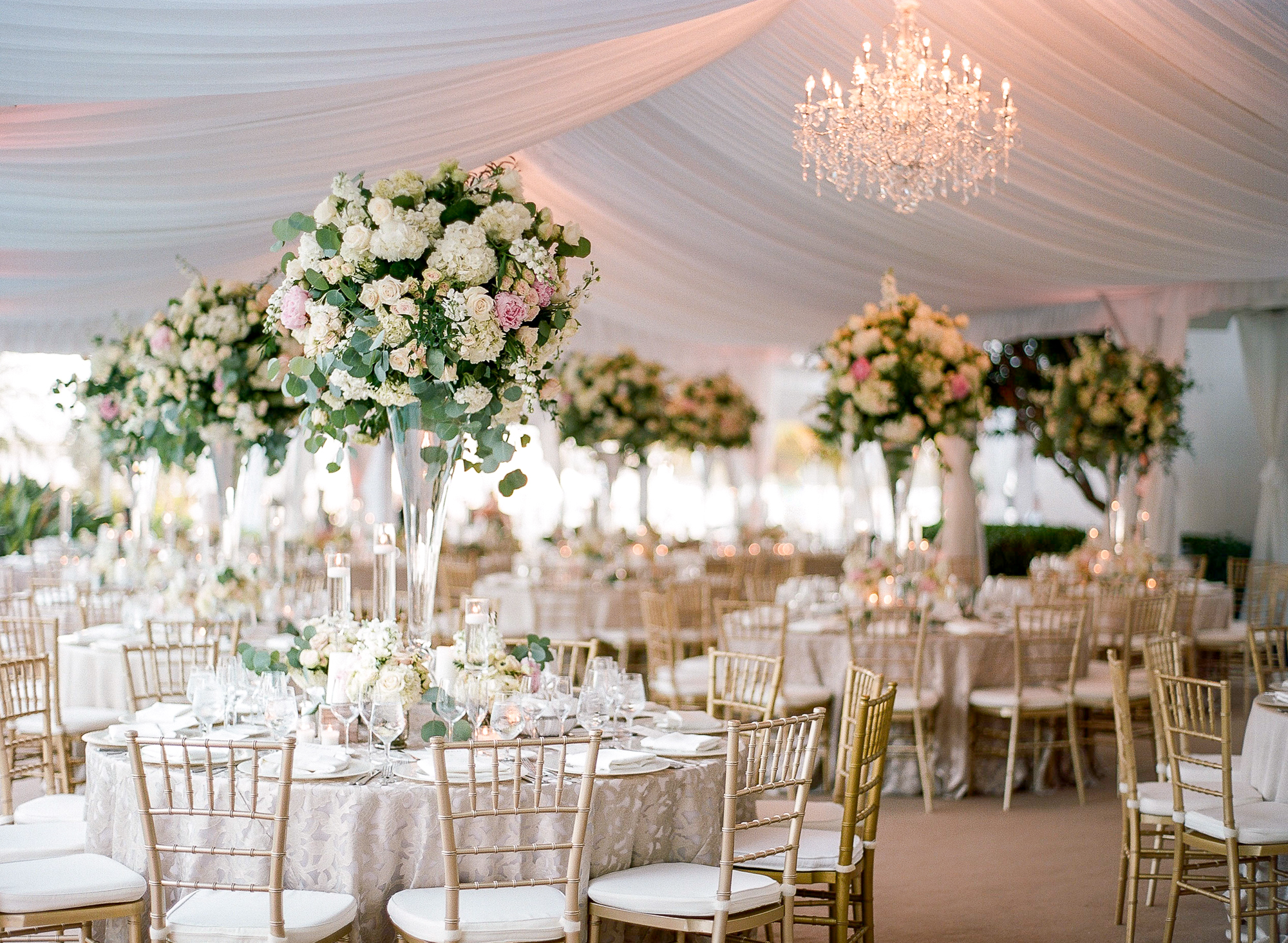The fisher island club terrace was carpeted and tented with beautiful white draping and chandeliers