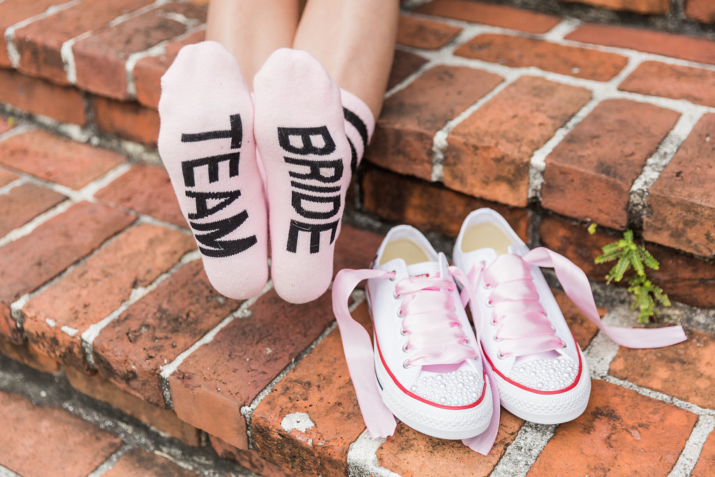 The bride wore custom Team Bride socks with pink satin lace bedazzled converse sneakers
