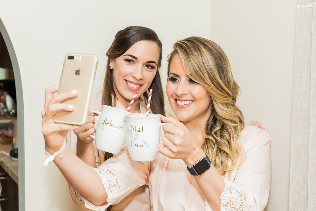 The bridesmaids take a photo with their custom coffee mugs