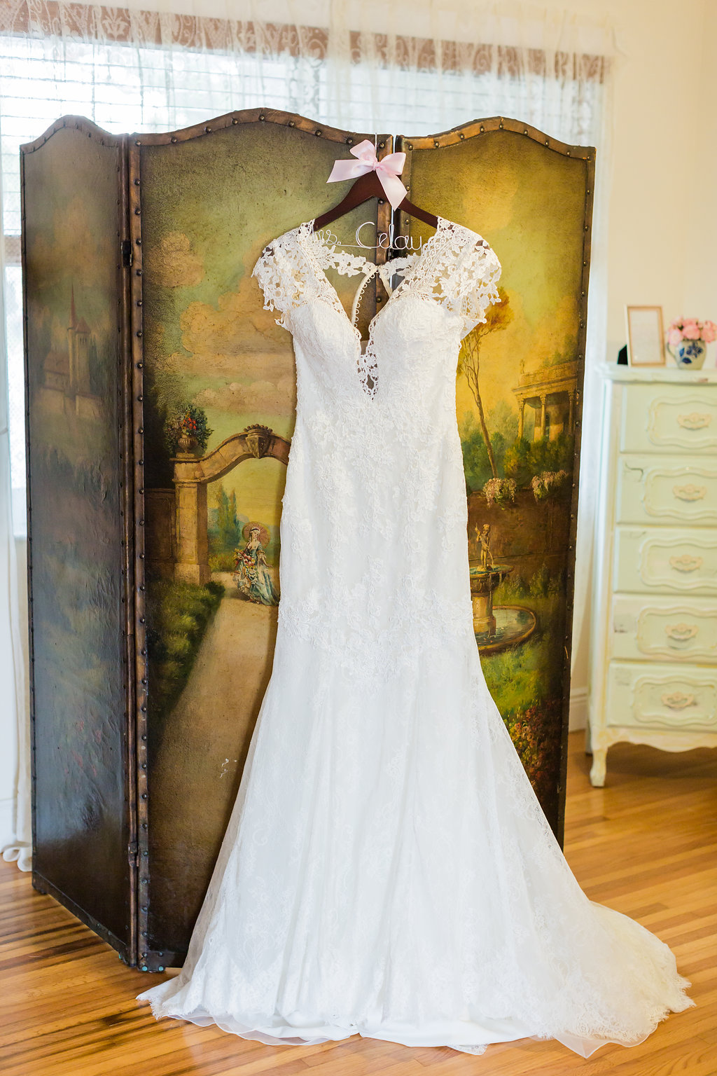 The bride's wedding dress is lace, open back, with beaded spine, lace detailing, lace cap sleeves and a low cut front