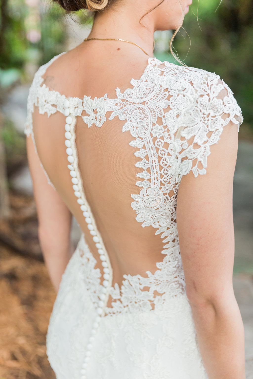 The bride wore a beautiful lace wedding dress with low back, beaded back, and lace cap sleeves
