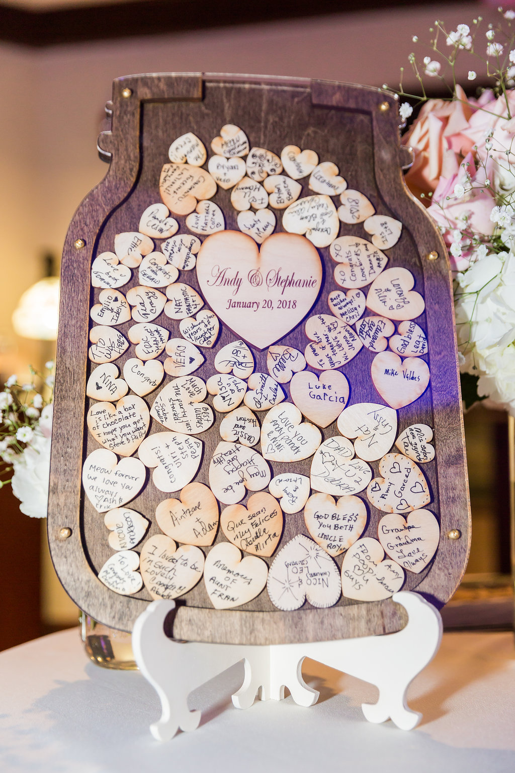 This wedding guest book was a custom mason jar frame with small wood hearts for people to sign and drop into the shadow box display