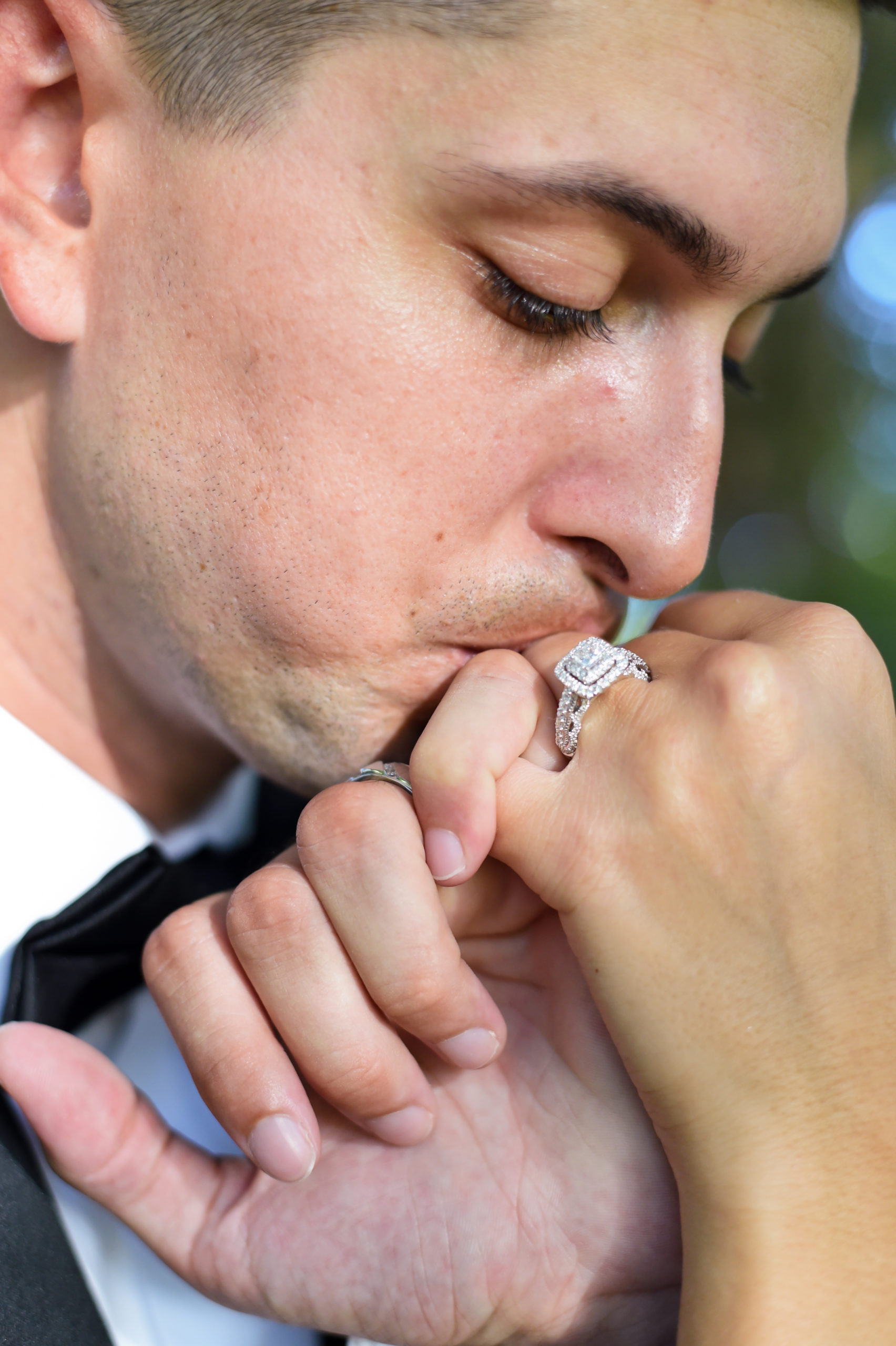 The groom kisses the bride's hand as it now adorns a wedding ring!