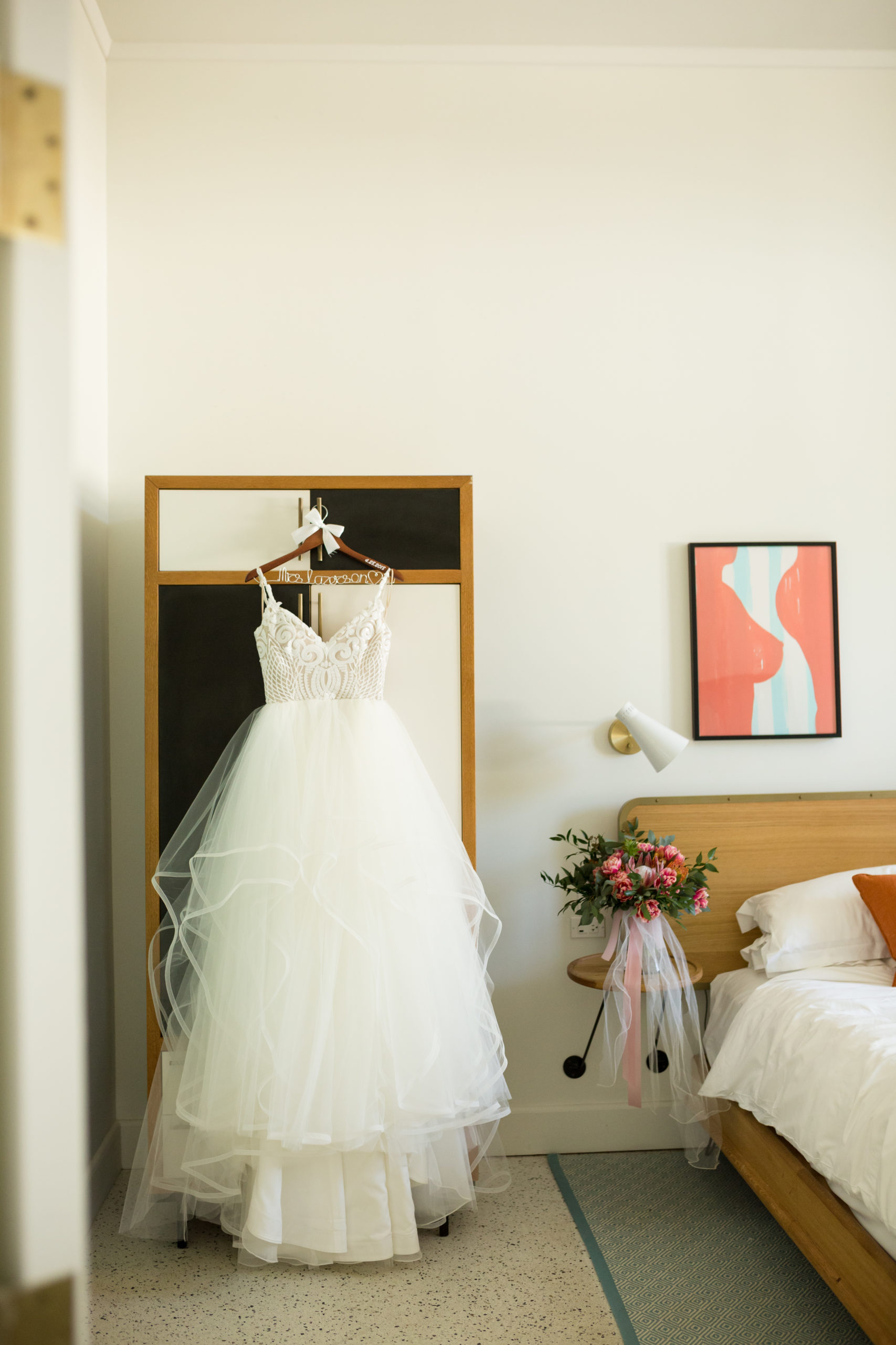 wedding dress hanging on a custom hanger at the confidante miami beach bridal suite