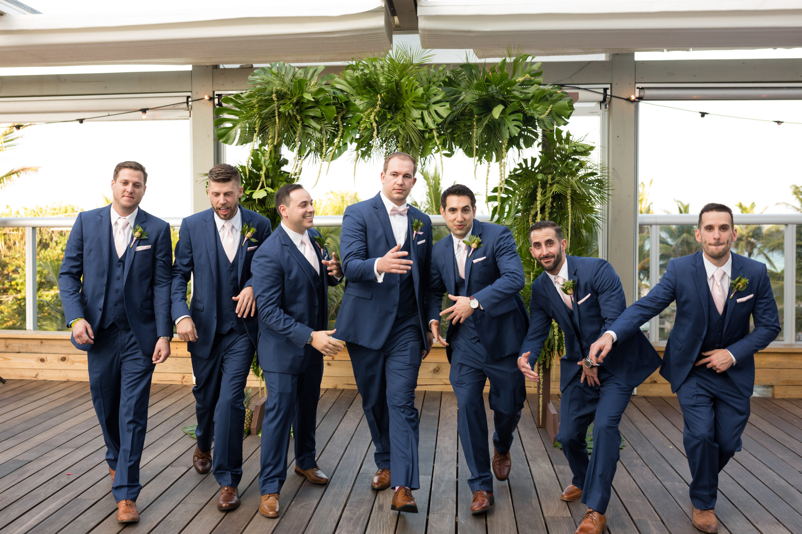 The groom and his groomsmen taking a funny picture after ceremony in their blue suits at the confidante miami beach