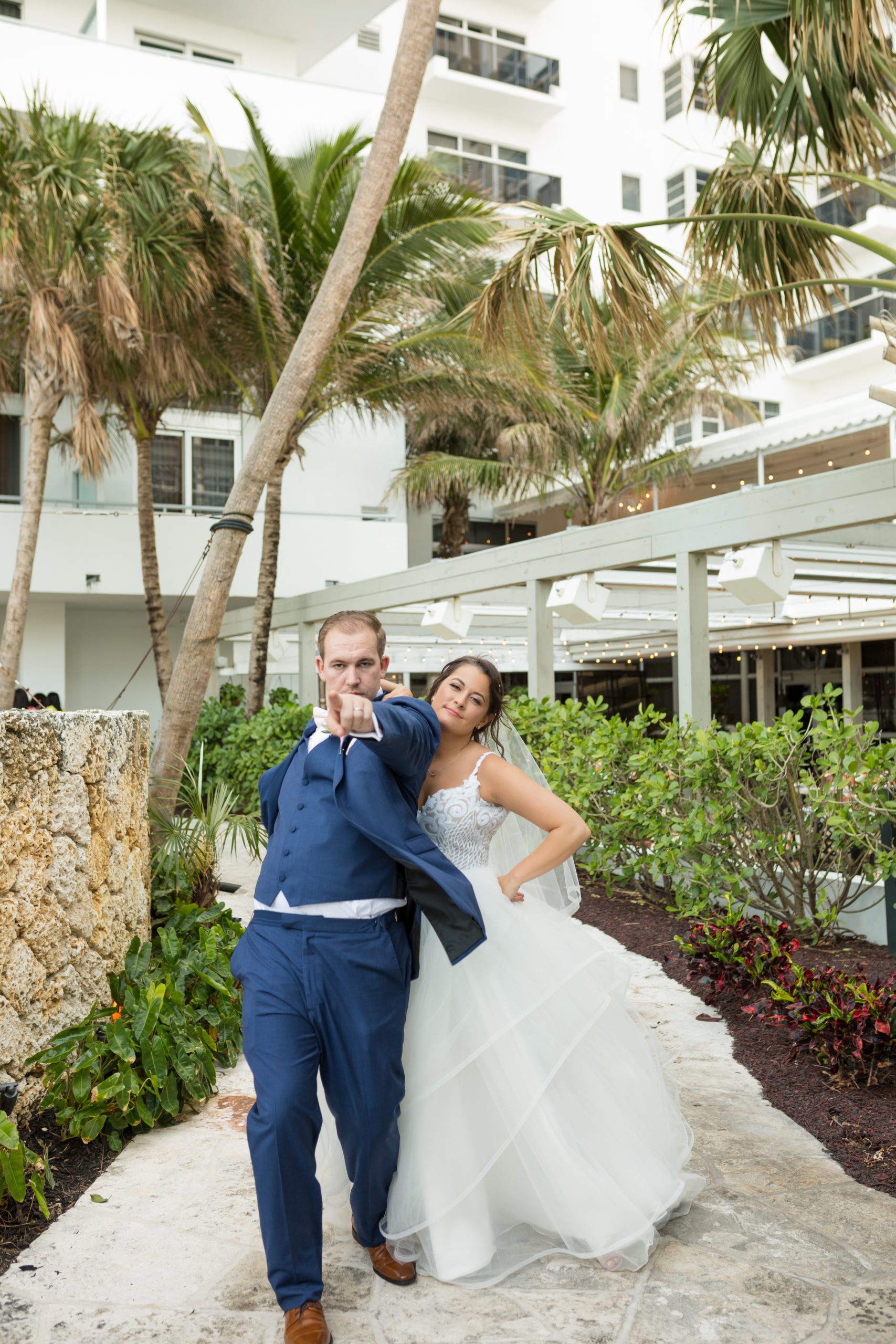 bride and groom acting silly for portraits after their ceremony at the confidante miami beach