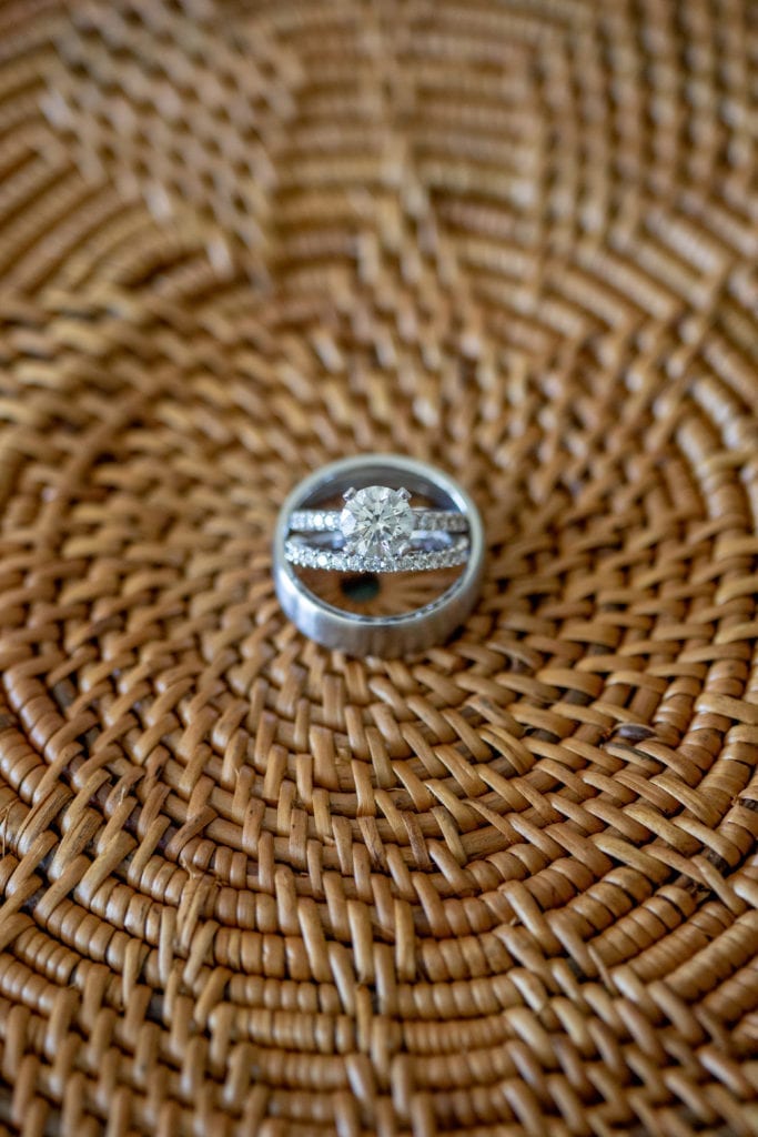 wedding rings displayed on a wicker purse