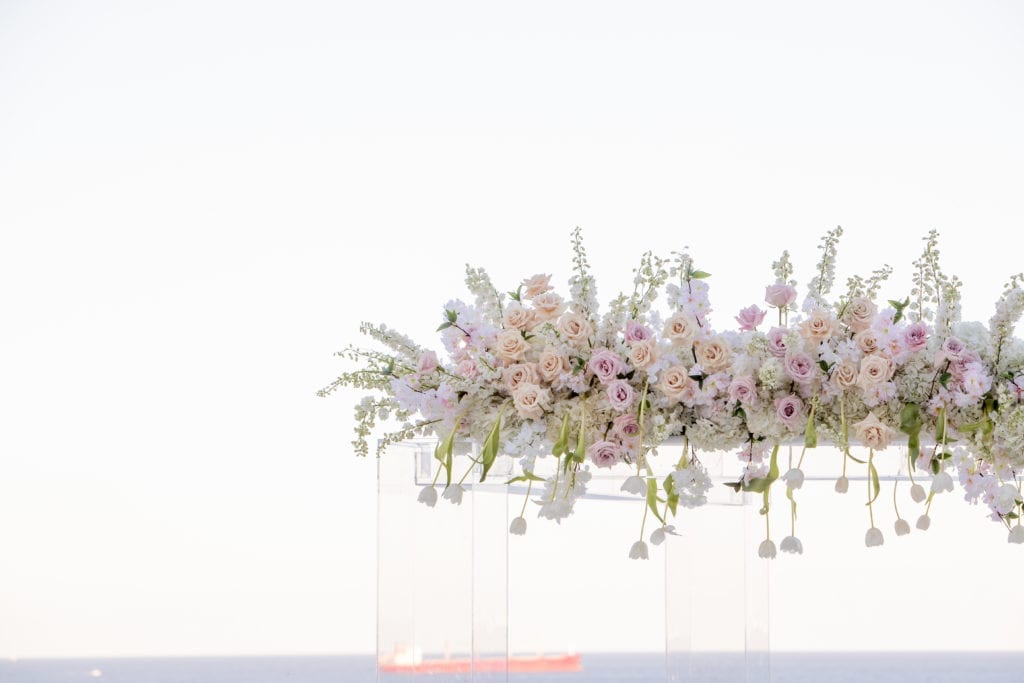 acrylic ceremony structure topped with flowers