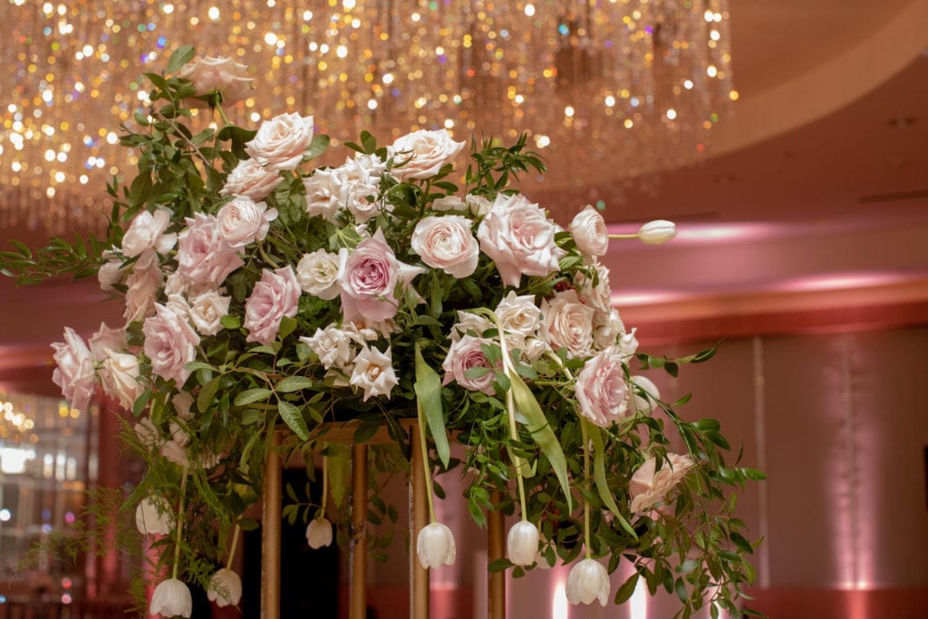 tall gold armature centerpiece held blush and ivory roses with greenery and hanging white tulips at Ritz Carlton Ft. Lauderdale