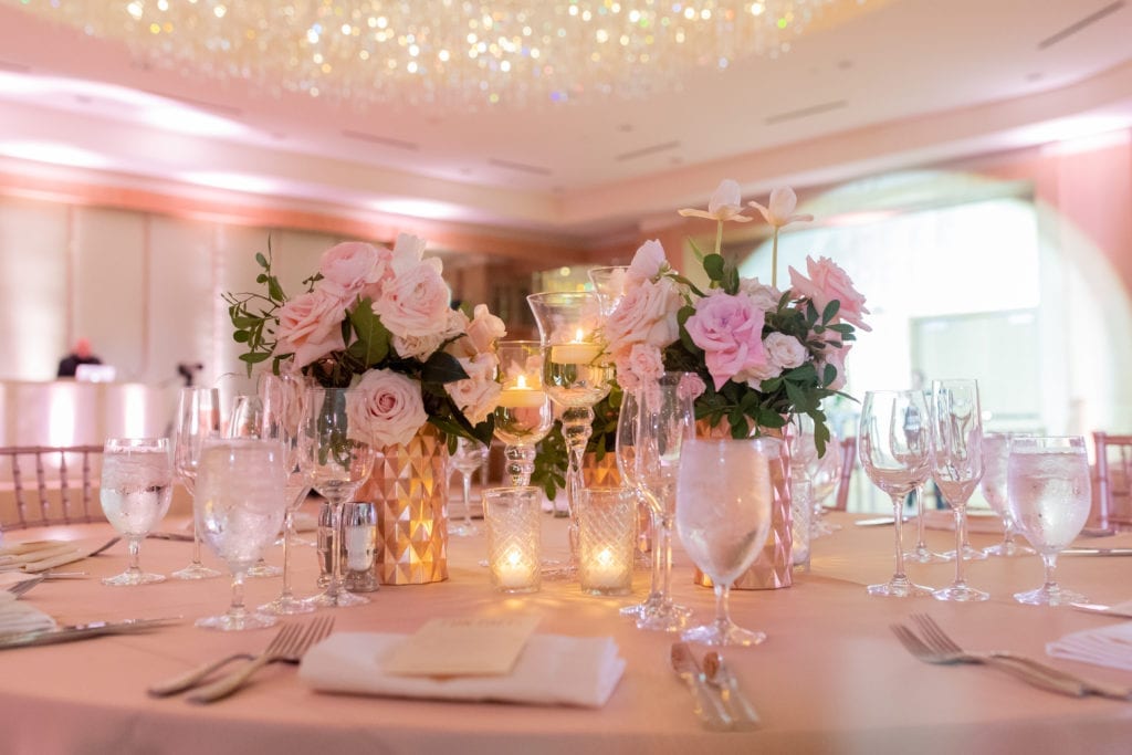 gold beveled vases with blush and ivory tulips and roses with greenery sit on top of a champagne colored linen at Ritz Carlton Ft. Lauderdale