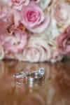 wedding rings in front of a blush bridal bouquet