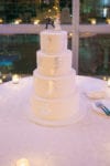 a silver foiled wedding cake with runaway groom cake topper