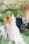 bride walks down the aisle with her mom and dad