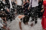 The bride lays in a layer of confetti during her reception at Rusty Pelican