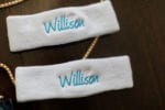 custom embroidered sweatbands in blue and pink feature the bride and groom's combined couple name