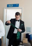 a groomsman admires his custom socks that include the faces of the bride and groom