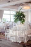 tall tropical centerpieces on top of a white linen table