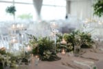 tropical centerpieces of green leaves line the long wedding table