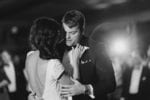 groom holds his bride right as they dance to their first dance