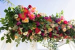 gorgeous colorful fuschia, blush, magenta, and greenery chuppah floral arrangement