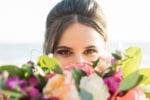 bridesmaid peeks her eyes behind her bouquet