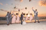 the wedding party jumps as they celebrate the bride and groom on the beach at La Playa Naples