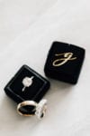 black velvet ring box with gold monogram and diamond ring