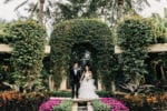 bride and groom hold hands in front of the Frenchman's Reserve garden