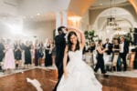 bride smiles as the groom spins her around during their dance