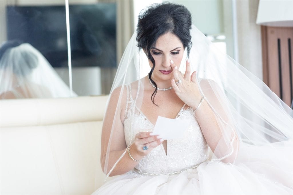 The bride shedding a tear as she reads a note at The Conrad Fort Lauderdale Beach, wedding planned by Oh My Occasions