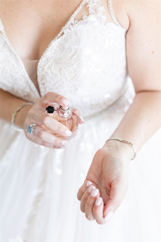 The bride spraying perfume on her wrists at The Conrad Fort Lauderdale Beach, wedding planned by Oh My Occasions