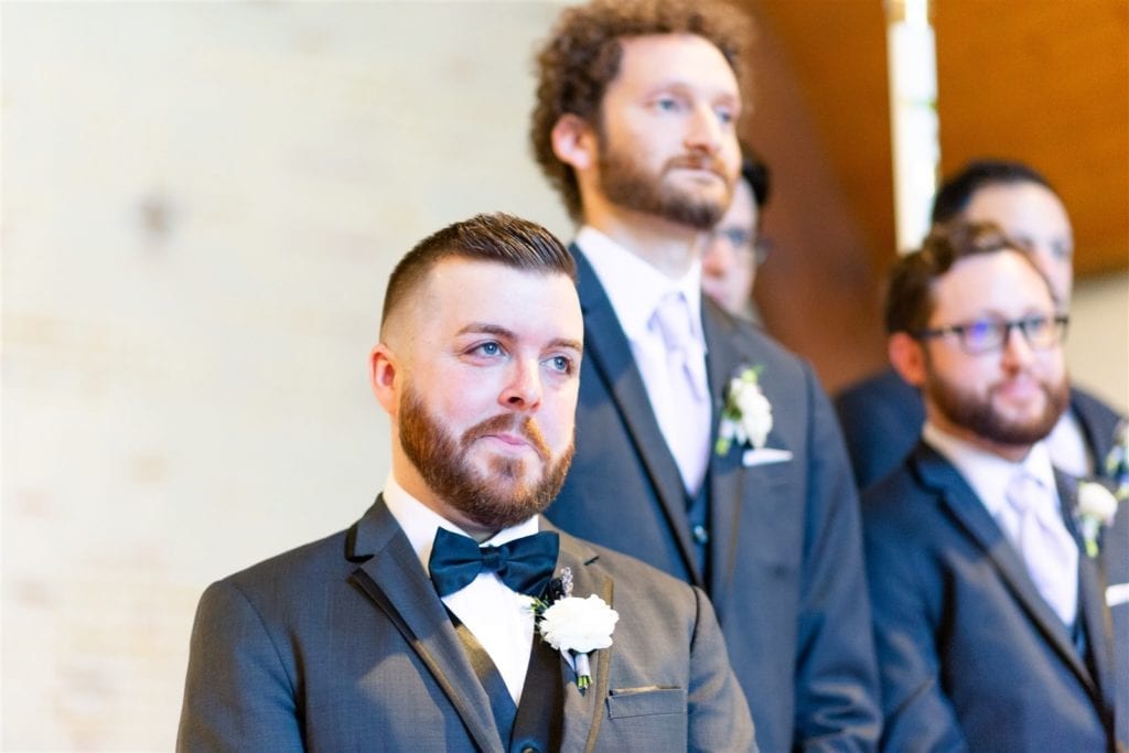 groom's reaction as he watches the bride walk down the aisle