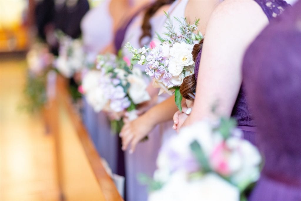 A closeup of the bridesmaids colorful bouquets with roses at St. Maurice Catholic Church