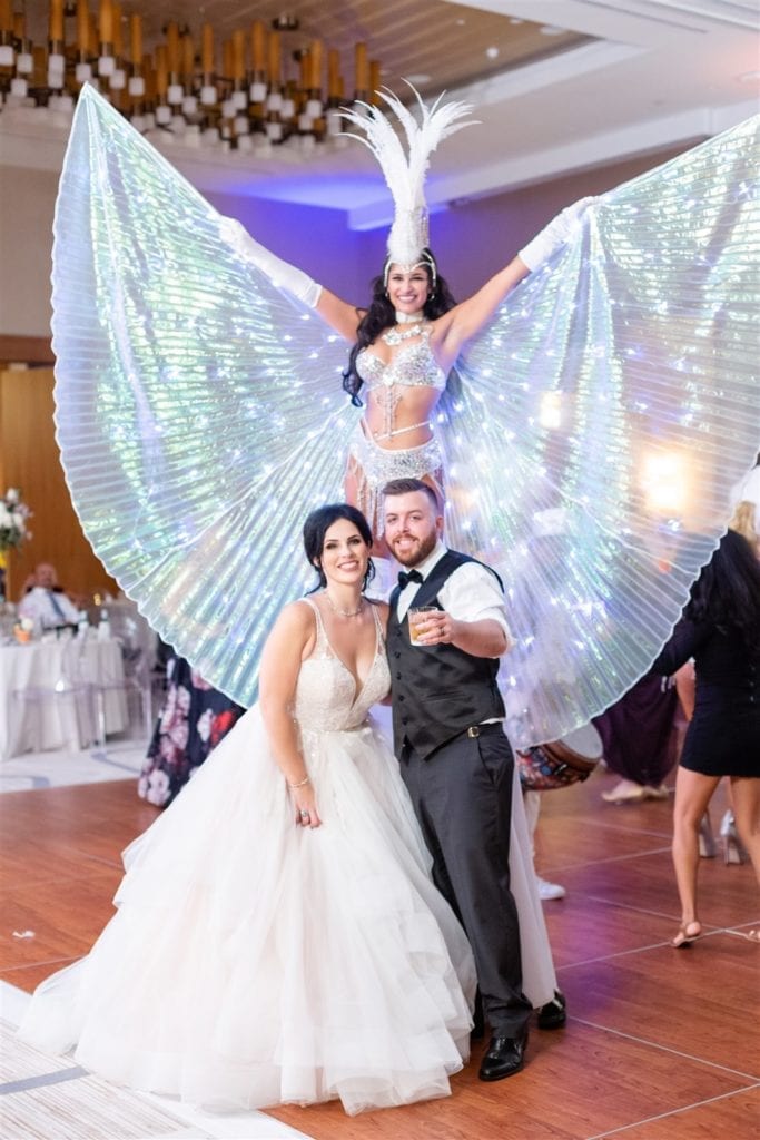 bride and groom pose with their hora loca performer in the Conrad Ft. Lauderdale ballroom