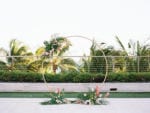 tropical miami beach edition wedding with gold circle ceremony arch and tropical flowers