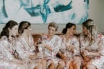 bridesmaids pour champagne in floral robes