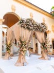 blush draped chuppah ceremony structure with pampas grass and roses at Biltmore Miami wedding country club courtyard
