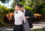 best man helps the groom into his jacket