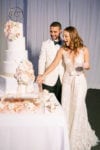 bride and groom cut their marble and gold hexagon wedding cake