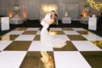 metallic gold and white checkerboard dance floor with feather wall and neon sign at JW Marriott Marquis Miami wedding designed by Oh My Occasions, a naples and tampa wedding planner